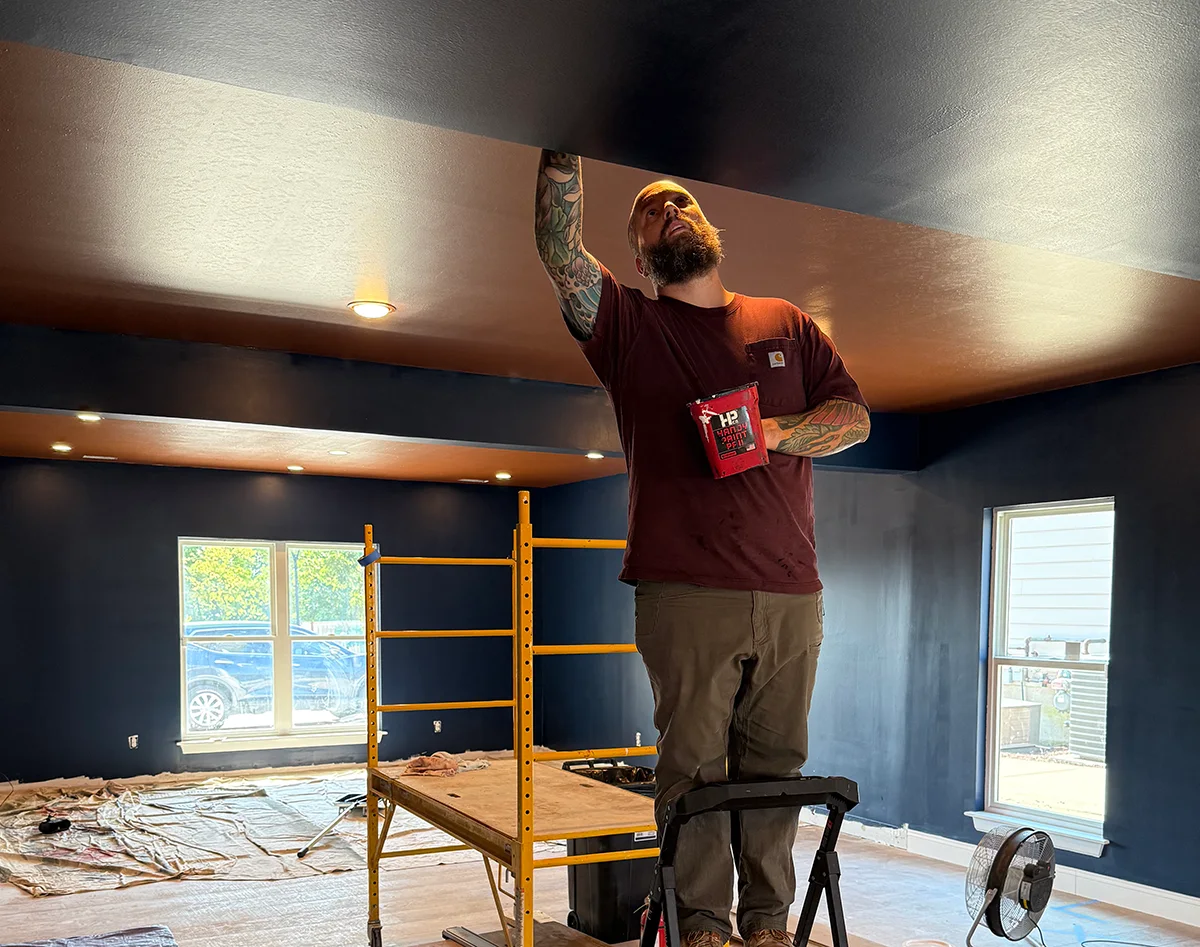 Micah paints the ceiling while preparing the future Men’s Modern General Store.